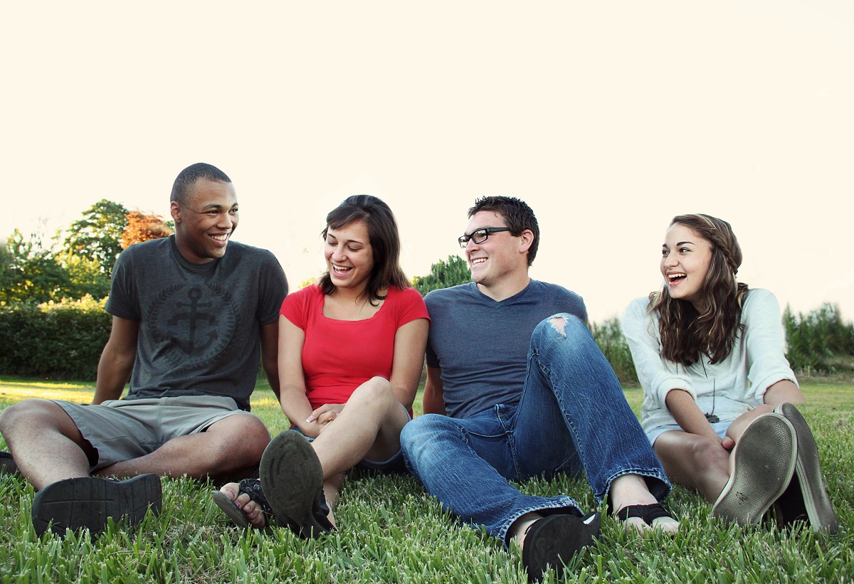 photo of a group of four friends sitting in the grass