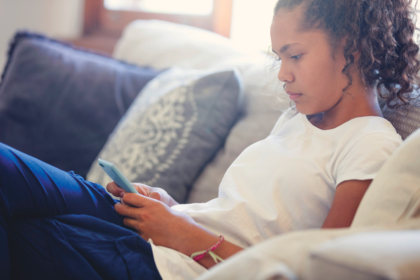 Stock photo of a teen looking at her cell phone