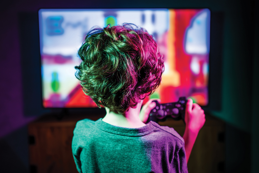 Stock photo of a child facing a large screen