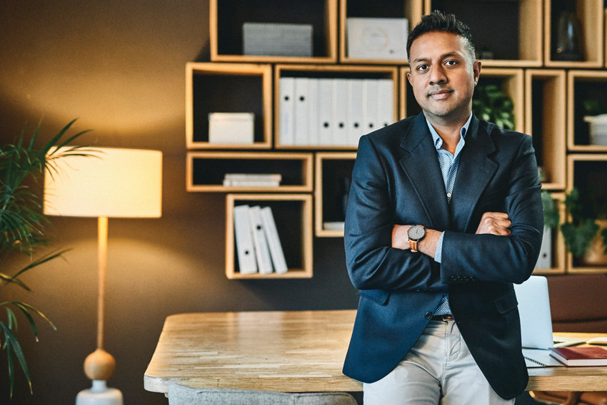 Stock photo of a man leaning against a desk