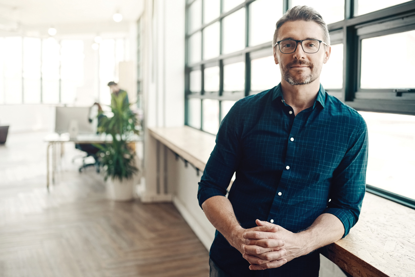 Stock photo of a man leaning against a counter