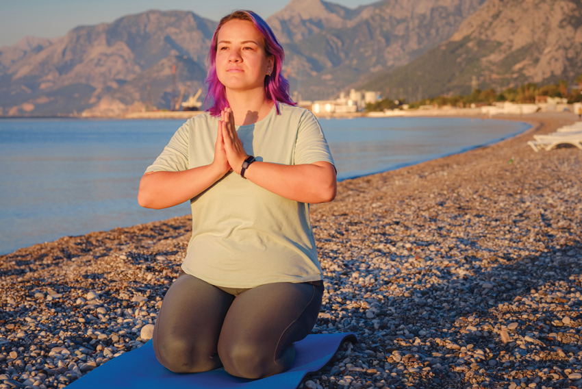Stock photo of a woman practicing yoga on the beach