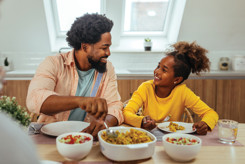Stock photo of a father and daughter eating a meal