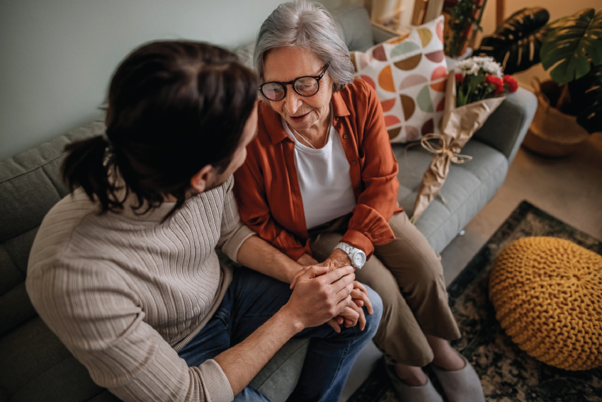 Stock image of elder woman and young man comforting each other