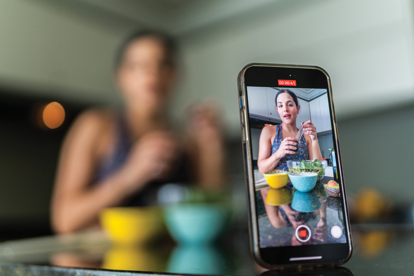 stock photo depicting a social media influencer filming themself on a phone