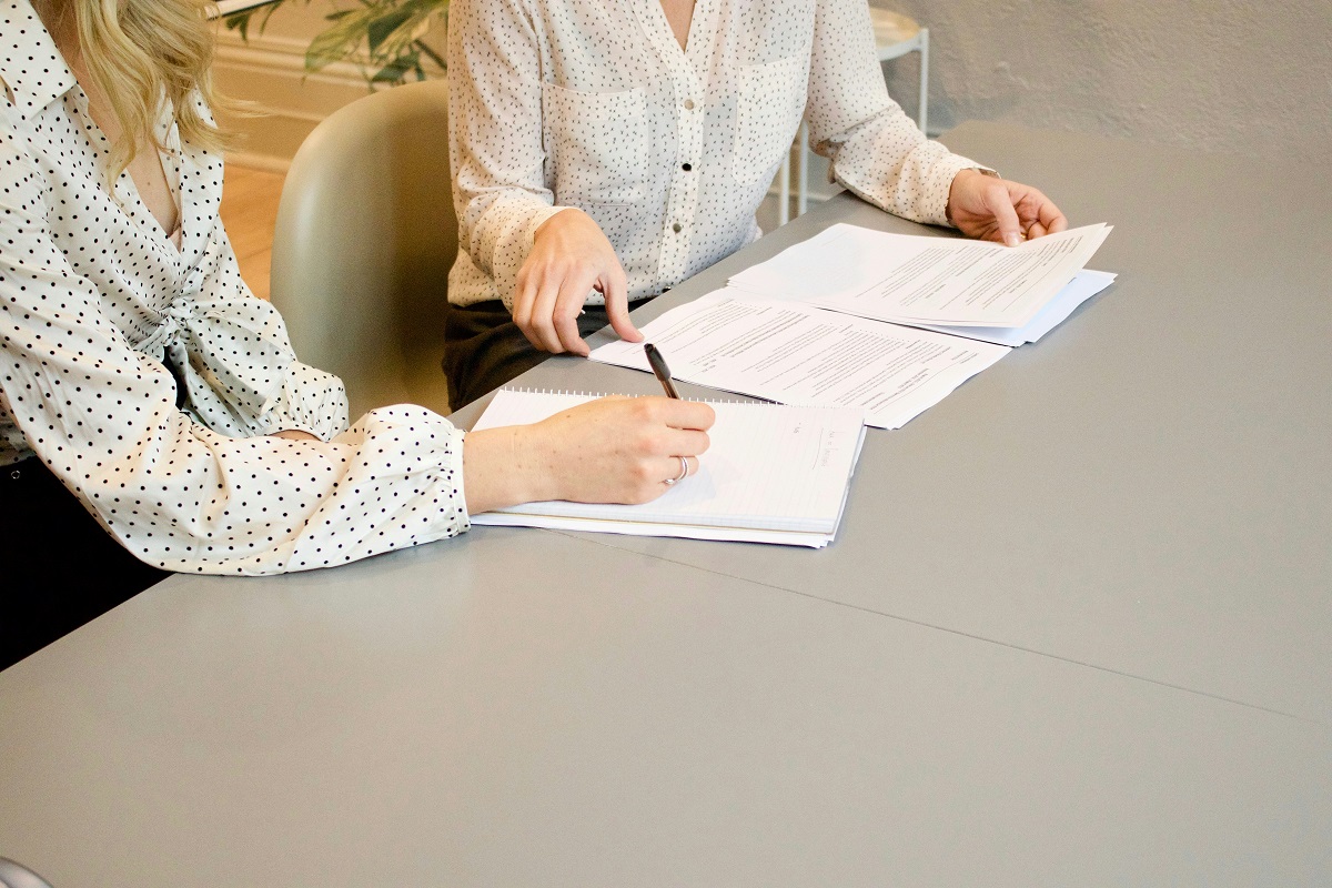 stock photo of two people sitting at a desk looking at documents