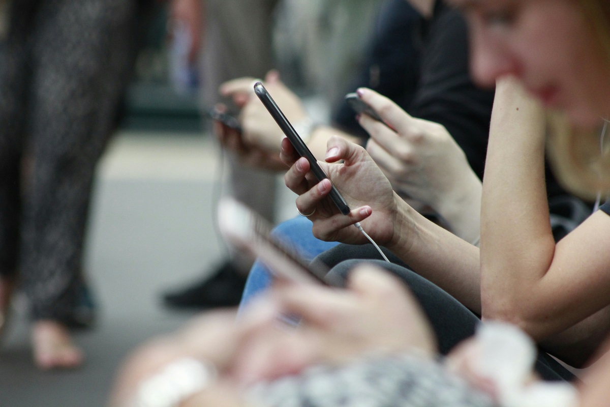 stock photo of people looking at their smartphones