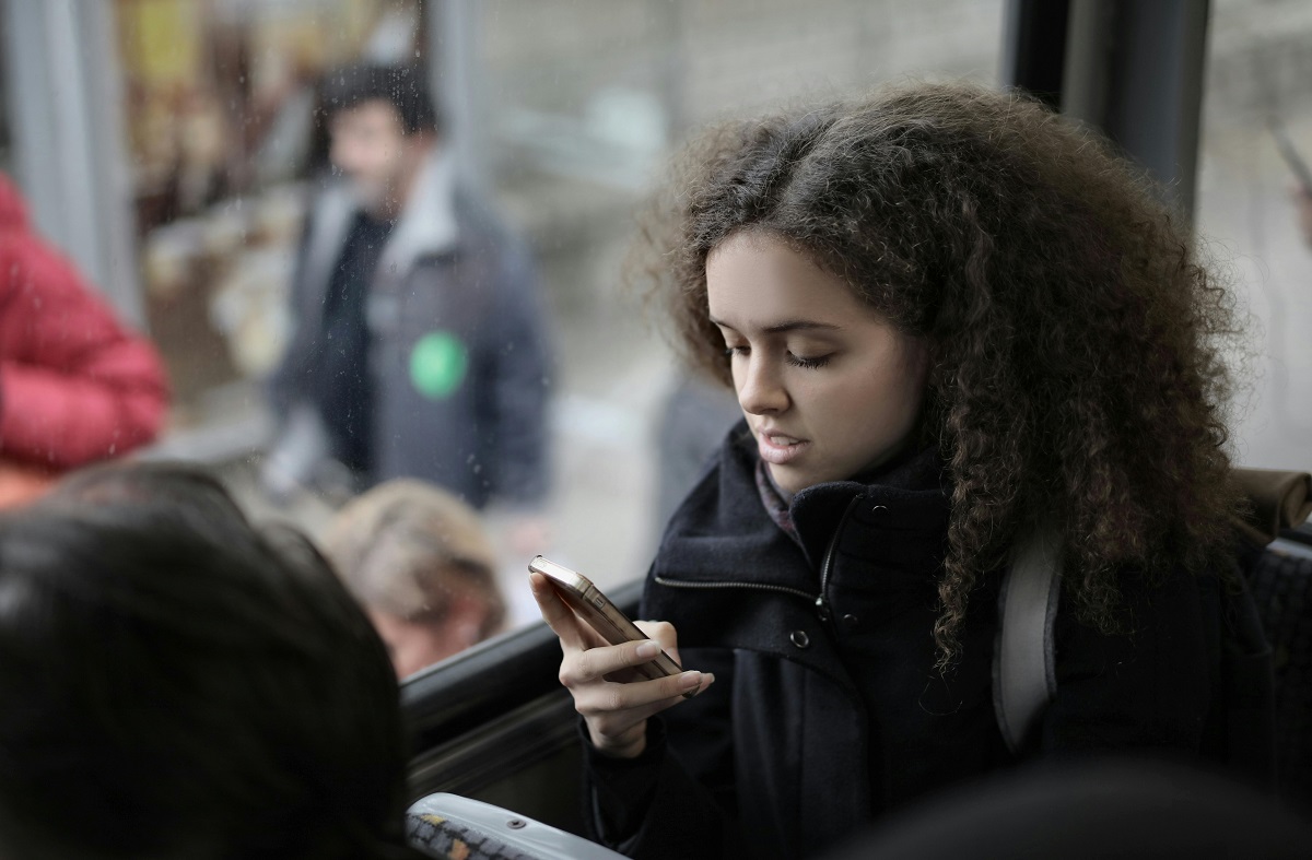 stock photo of a person looking at their phone while riding a bus