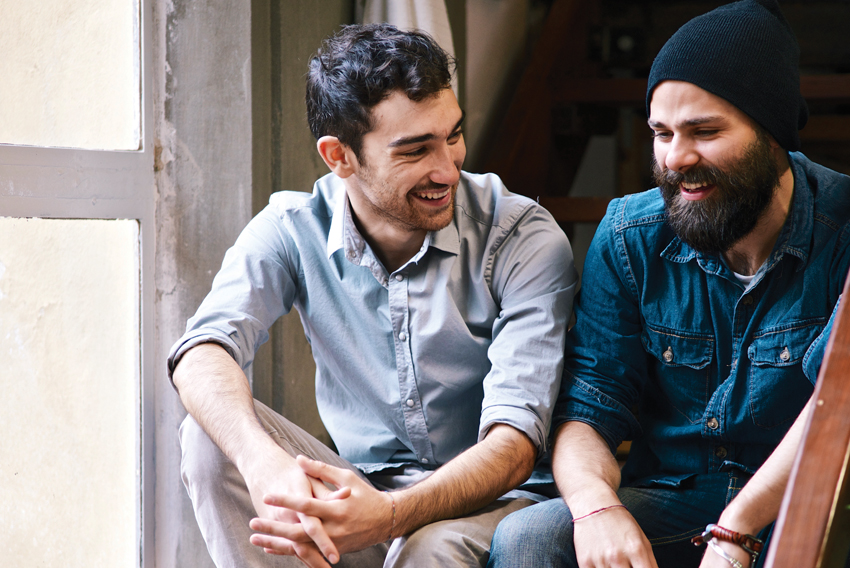 Stock photo of two men talking and smiling