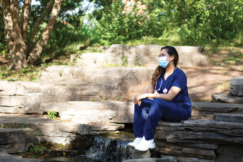 Stock photo of health care worker sitting alone in nature